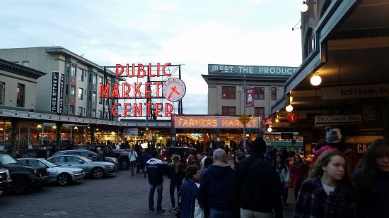 The Seattle Market Center square filled with people walking past stands